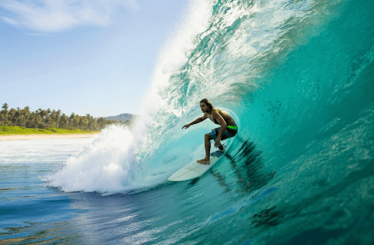 A surfer carving through a wave on a high-tech electric surfboard