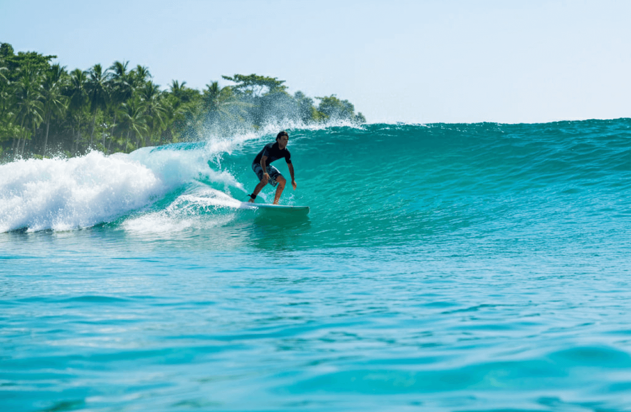 A man confidently riding a wave on a stable surfboard for beginners